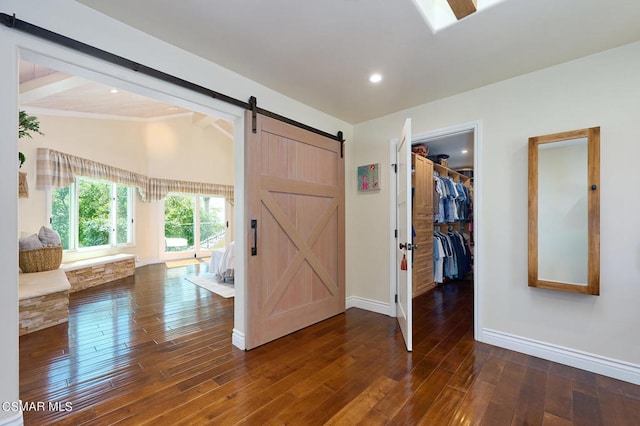 foyer with lofted ceiling with beams, a barn door, and dark wood-type flooring