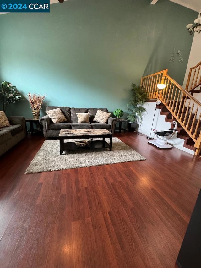 living room featuring vaulted ceiling and dark wood-type flooring