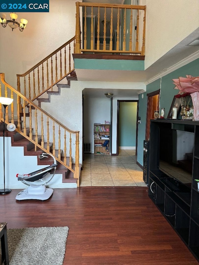 staircase featuring a high ceiling, hardwood / wood-style floors, and crown molding