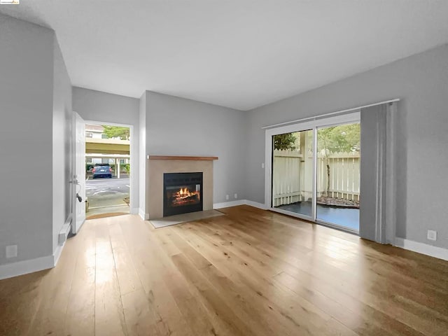 unfurnished living room featuring light wood-type flooring and plenty of natural light