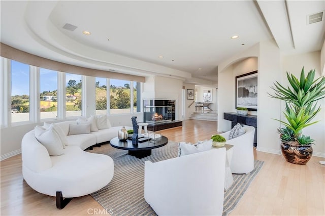 living room featuring a high end fireplace and light wood-type flooring