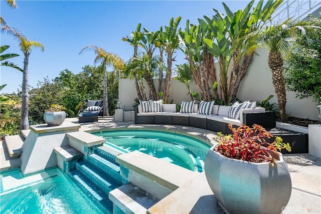 view of pool with an outdoor living space, an in ground hot tub, and a patio area