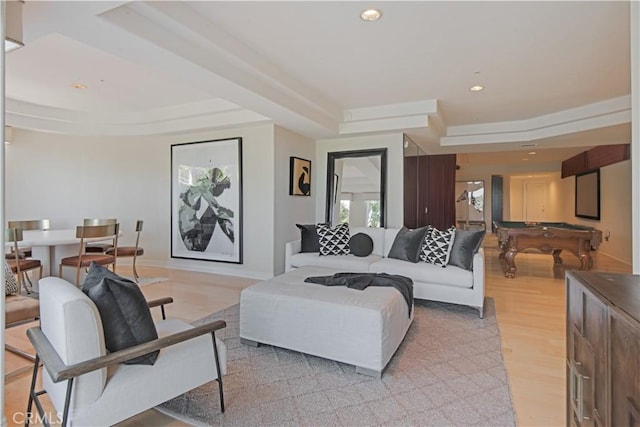 living room featuring a tray ceiling and light hardwood / wood-style floors