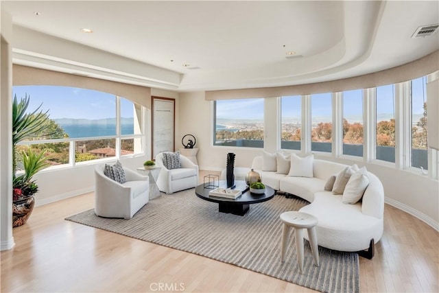 living room with a water and mountain view and light wood-type flooring