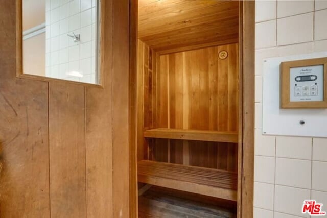 view of sauna featuring wooden ceiling, wood walls, and hardwood / wood-style floors