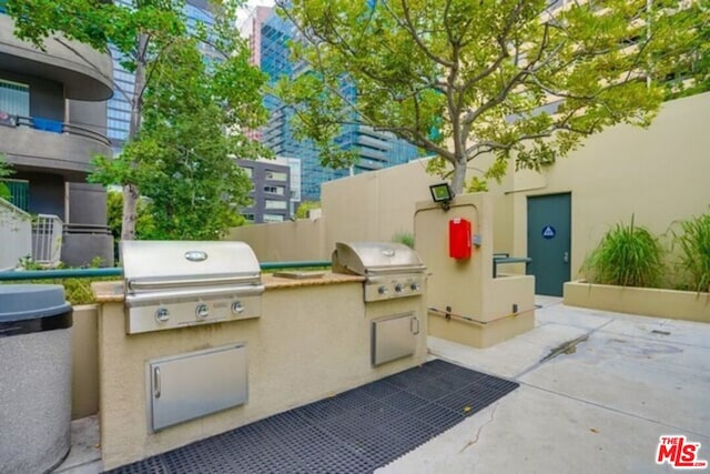 view of patio / terrace with a balcony, exterior kitchen, and a grill