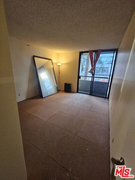 unfurnished room with a textured ceiling