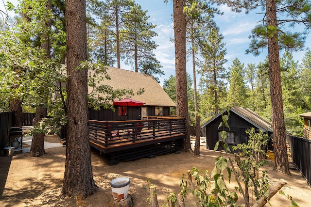 rear view of house featuring a storage unit, a patio, and a deck