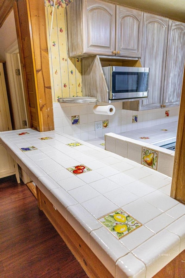 kitchen featuring tile countertops, light brown cabinets, dark wood-type flooring, and tasteful backsplash