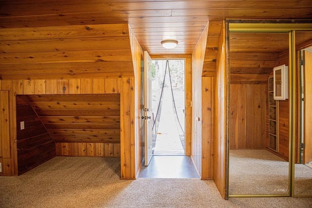 interior space with carpet floors, wooden ceiling, lofted ceiling, and wood walls