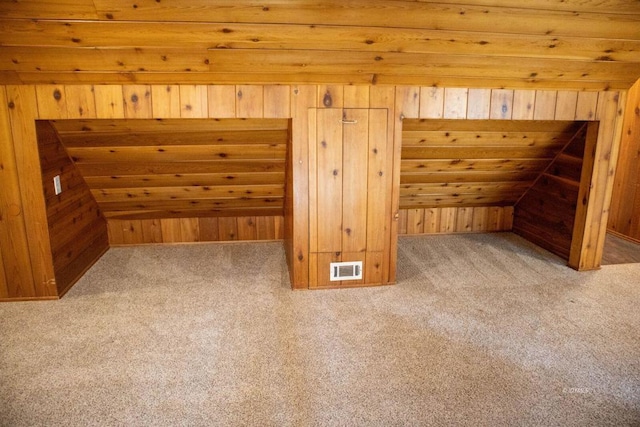 additional living space featuring wood walls, carpet floors, and vaulted ceiling