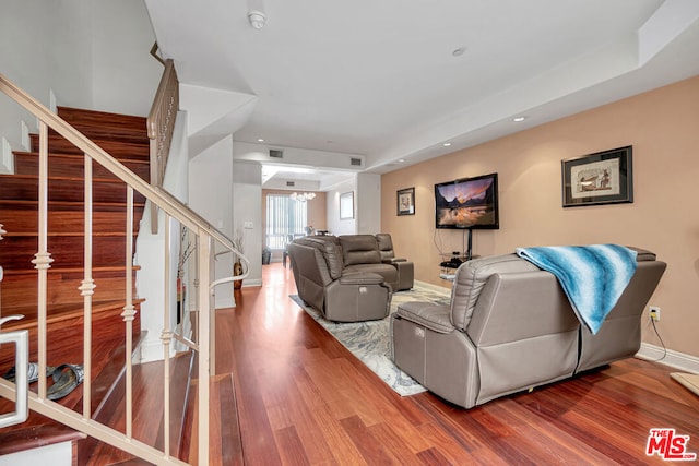 living room featuring a tray ceiling and dark hardwood / wood-style flooring