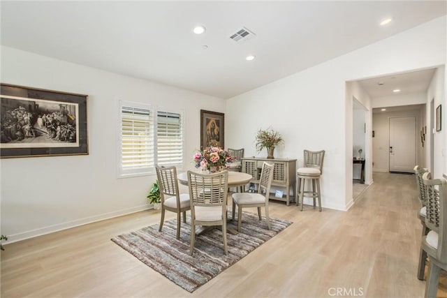 dining area with lofted ceiling and light wood-type flooring