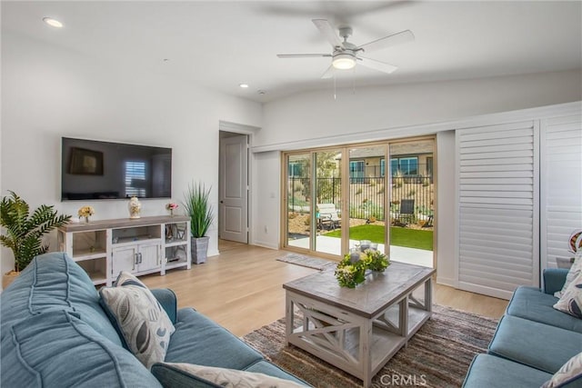 living room with ceiling fan, light wood-type flooring, and vaulted ceiling