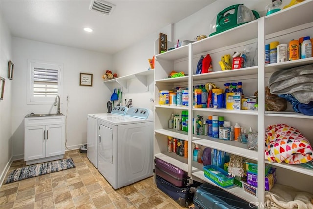 laundry room featuring washer and clothes dryer, cabinets, and sink