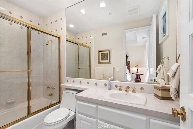 bathroom featuring toilet, recessed lighting, shower / bath combination with glass door, visible vents, and vanity