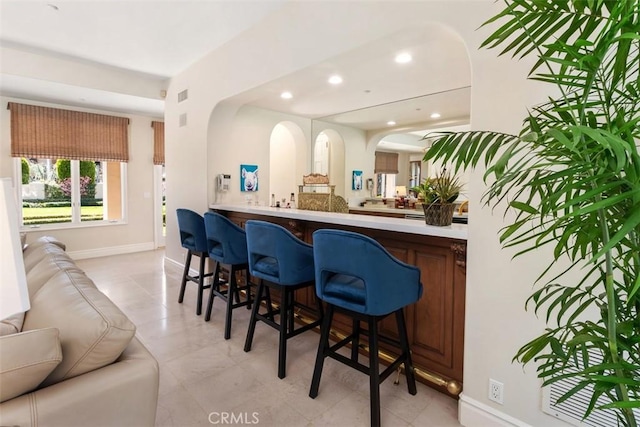 bar with baseboards, bar area, visible vents, and recessed lighting