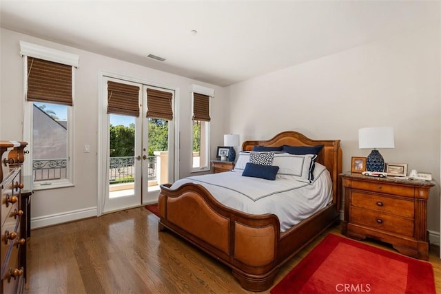 bedroom featuring wood finished floors, visible vents, baseboards, access to outside, and french doors