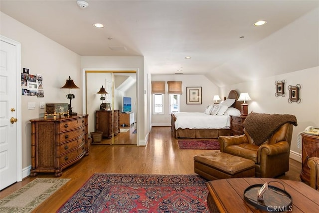 bedroom featuring recessed lighting, lofted ceiling, baseboards, and wood finished floors