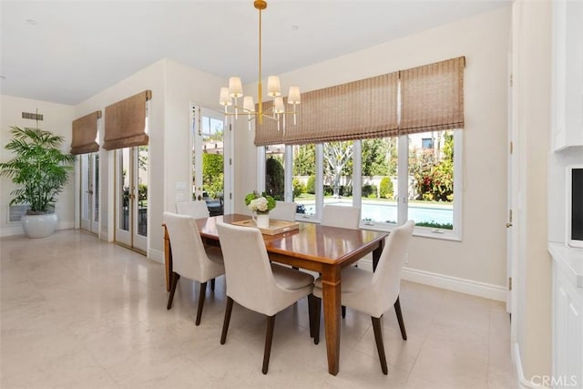 dining room with baseboards, visible vents, a wealth of natural light, and a notable chandelier