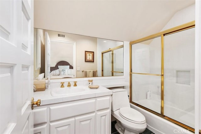 ensuite bathroom with visible vents, toilet, combined bath / shower with glass door, vanity, and ensuite bath