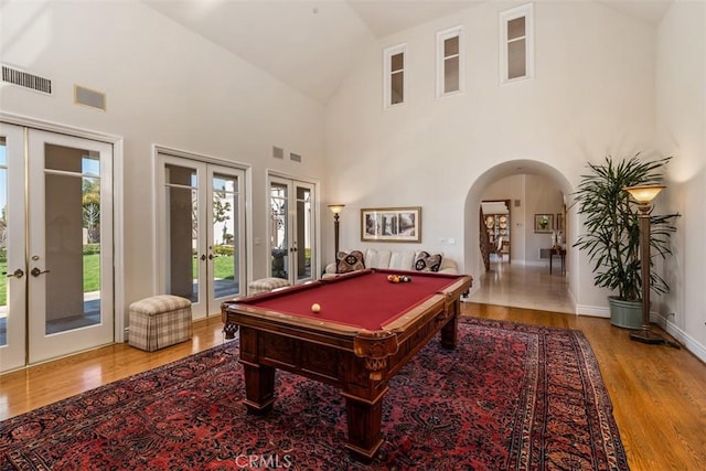 rec room featuring arched walkways, pool table, wood finished floors, visible vents, and french doors