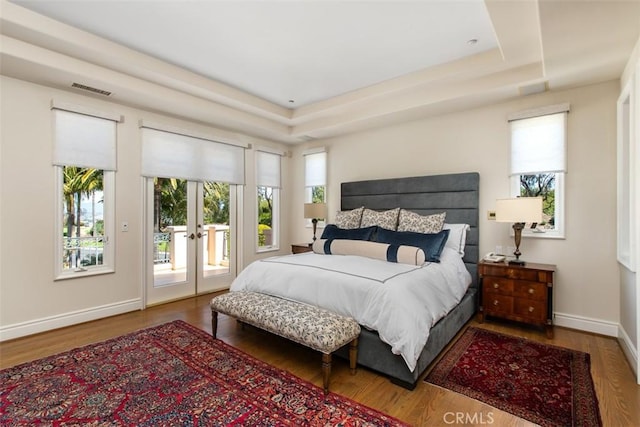 bedroom featuring french doors, visible vents, wood finished floors, access to outside, and baseboards