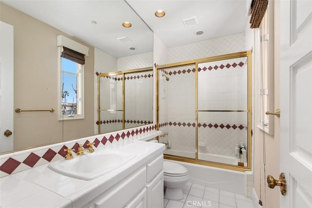 full bath featuring bath / shower combo with glass door, visible vents, toilet, vanity, and tile patterned flooring