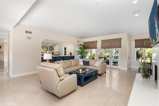 living room featuring recessed lighting, french doors, visible vents, and baseboards