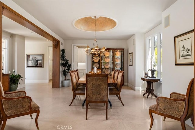 dining room featuring baseboards, visible vents, and a notable chandelier