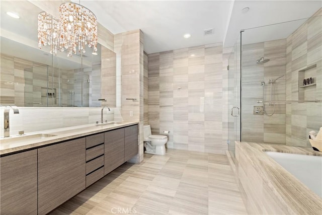 bathroom with an enclosed shower, vanity, tile walls, a chandelier, and toilet