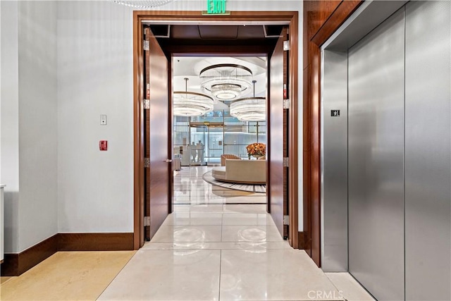 hall featuring light tile patterned floors and elevator