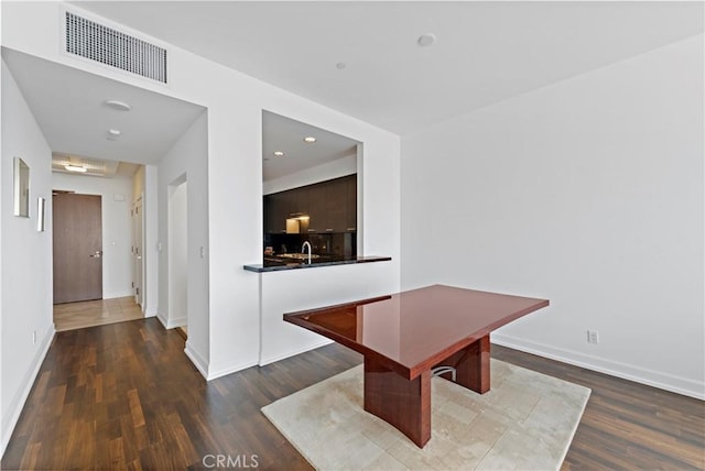 unfurnished dining area featuring sink and dark hardwood / wood-style floors