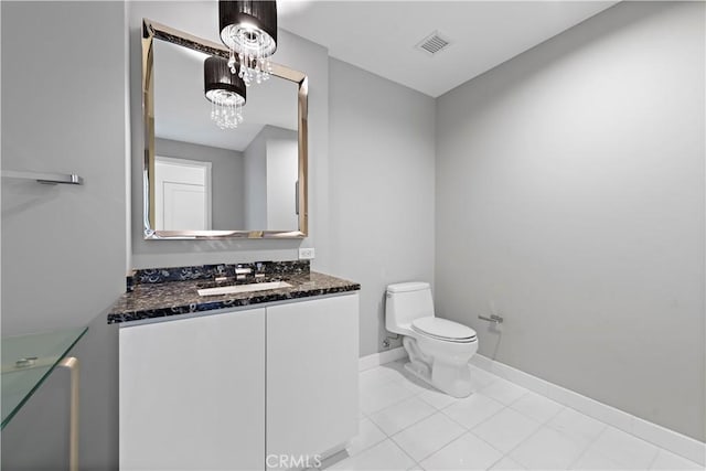 bathroom featuring tile patterned flooring, vanity, and toilet