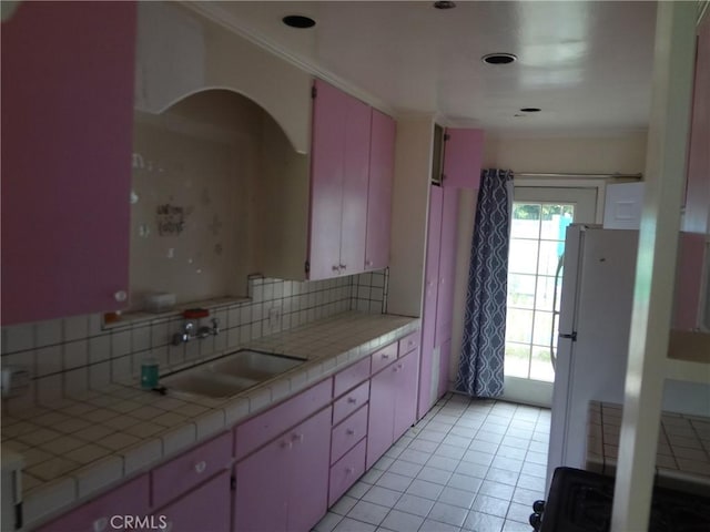 kitchen with tile counters, sink, white refrigerator, backsplash, and light tile patterned floors