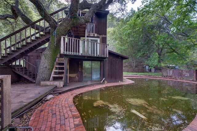 back of property featuring stairs and fence