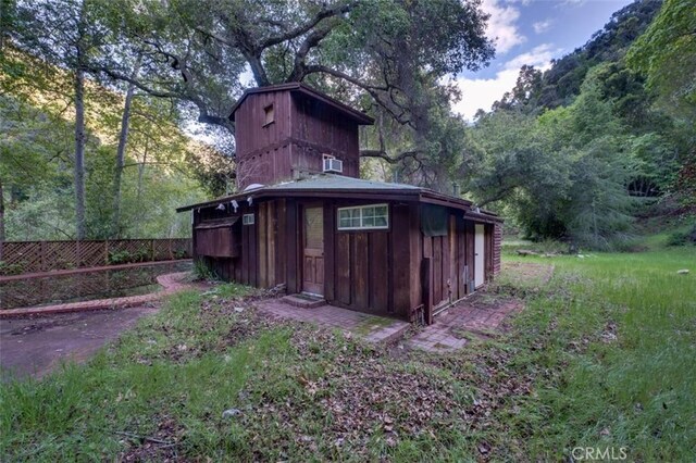 view of outdoor structure featuring an outbuilding and fence