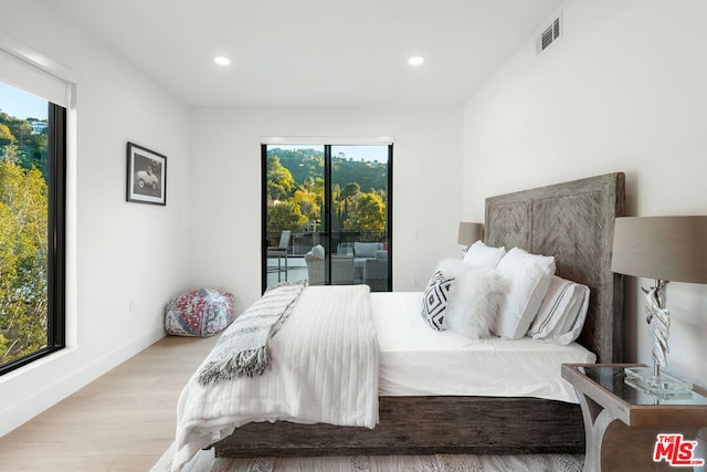 bedroom with access to outside and light wood-type flooring