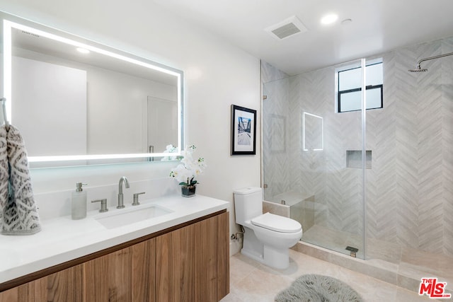 bathroom with an enclosed shower, toilet, vanity, and tile flooring