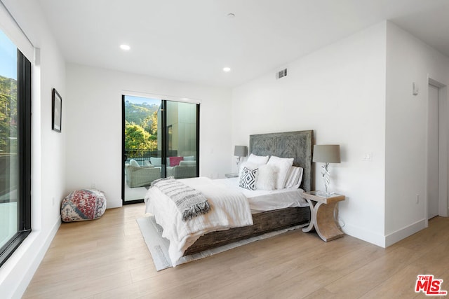 bedroom with access to exterior and light hardwood / wood-style floors