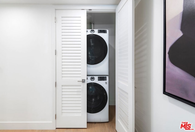 laundry area with stacked washer / dryer and light hardwood / wood-style floors