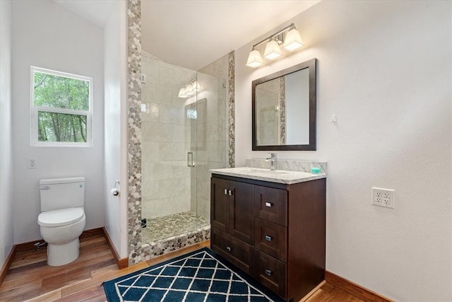 bathroom featuring hardwood / wood-style floors, walk in shower, vanity, and toilet