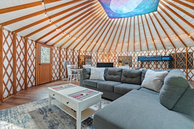 unfurnished living room featuring wood-type flooring and vaulted ceiling