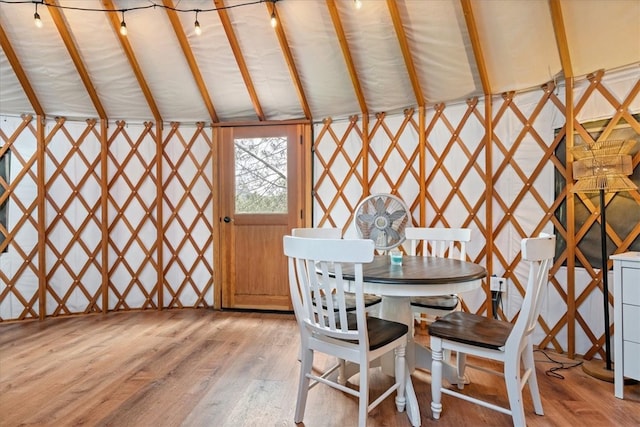 dining space with light hardwood / wood-style floors and vaulted ceiling