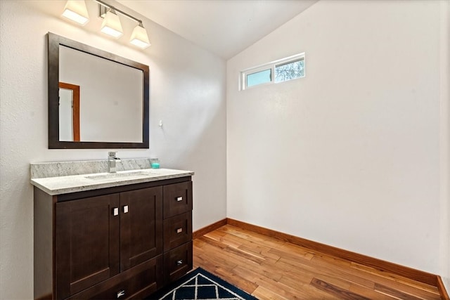 bathroom featuring vaulted ceiling, vanity, and hardwood / wood-style flooring