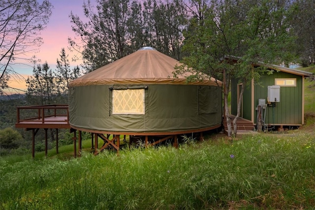 property exterior at dusk featuring a deck