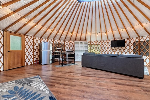 unfurnished living room featuring hardwood / wood-style floors and vaulted ceiling