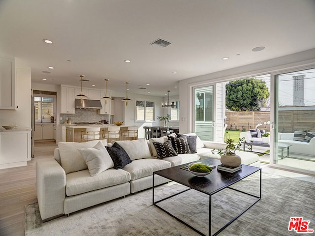 living room featuring an inviting chandelier and light hardwood / wood-style floors