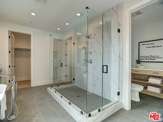 bathroom featuring toilet, tile floors, and a shower with shower door