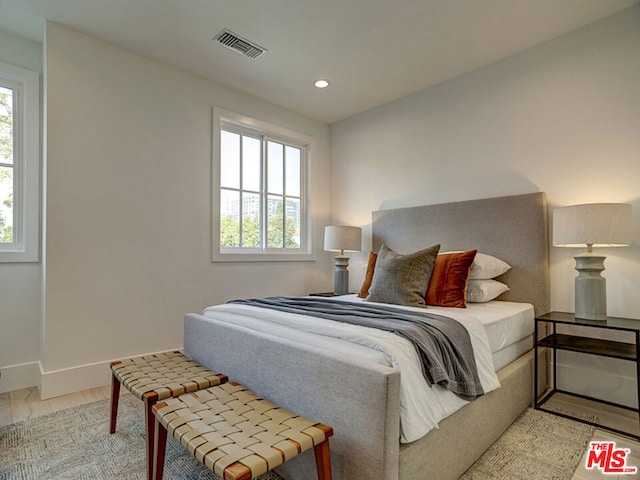 bedroom featuring multiple windows and light hardwood / wood-style flooring